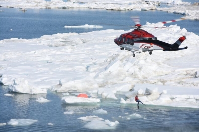 A helicopter crew lowers rescue swimmer into the Arctic Ocean during a joint exercise with the Coast Guard and other private firms to assess using manned and unmanned aerial systems for search and rescue near Oliktok Point, Alaska, July 13, 2015. The test took place in DOE airspace recently approved for research by the FAA (Coast Guard photo by Petty Officer 2nd Class Grant Devuyst).
