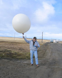 ARM Operations staff check out the radiosonde sensor package prior to launch during pre-experiment testing in Barrow, Alaska.