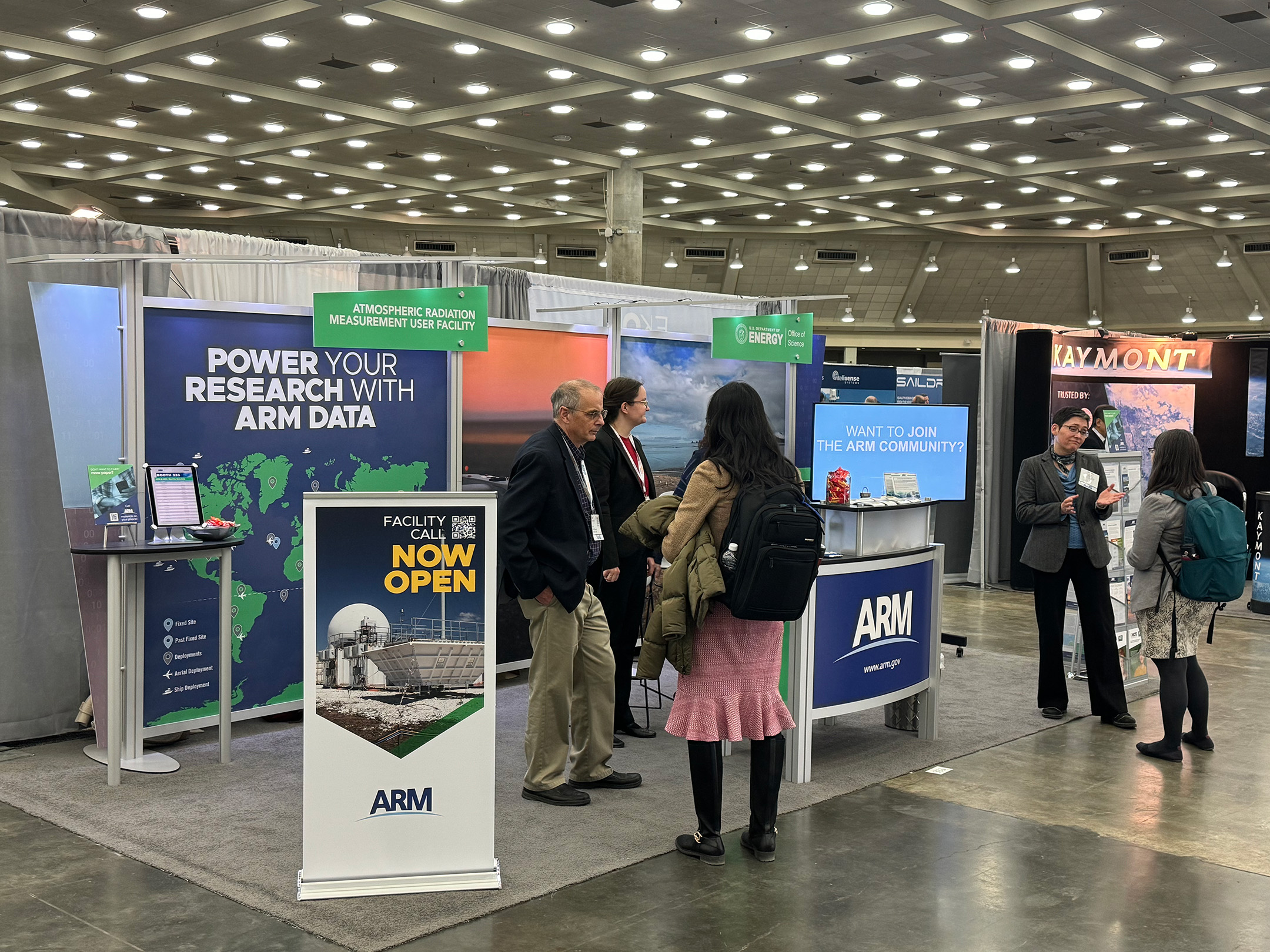 Conference attendees chat with ARM and ASR representatives at the ARM booth during the 2024 American Meteorological Society Annual Meeting