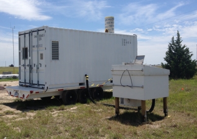 An AERI (front right) provided by ARM to measure infrared radiance from the atmosphere, with a water vapor lidar from NCAR (background) at the Ellis, Kansas, fixed PISA site. 