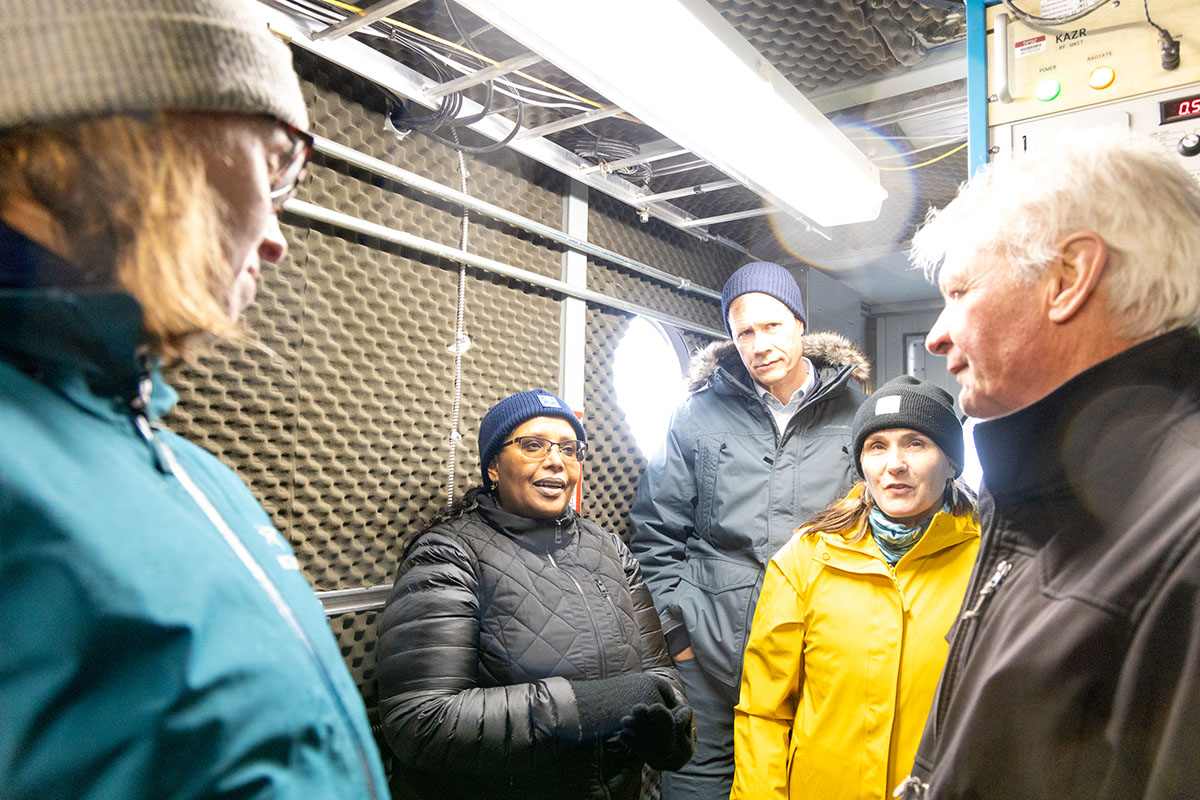 Sun streams into an instrument shelter as Dr. Berhe talks with Mark Ivey.