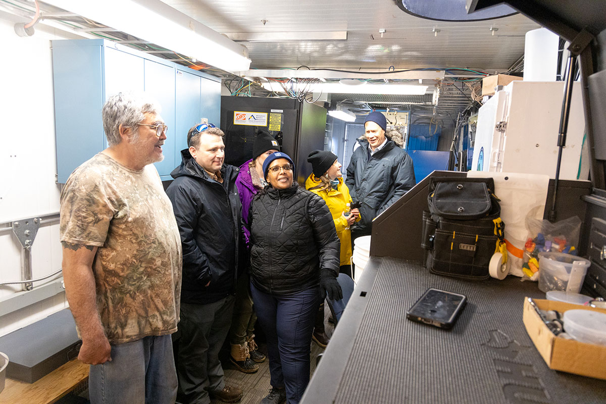 Dr. Berhe looks up at an item inside the main shelter as Jimmy Ivanoff discusses the instruments.