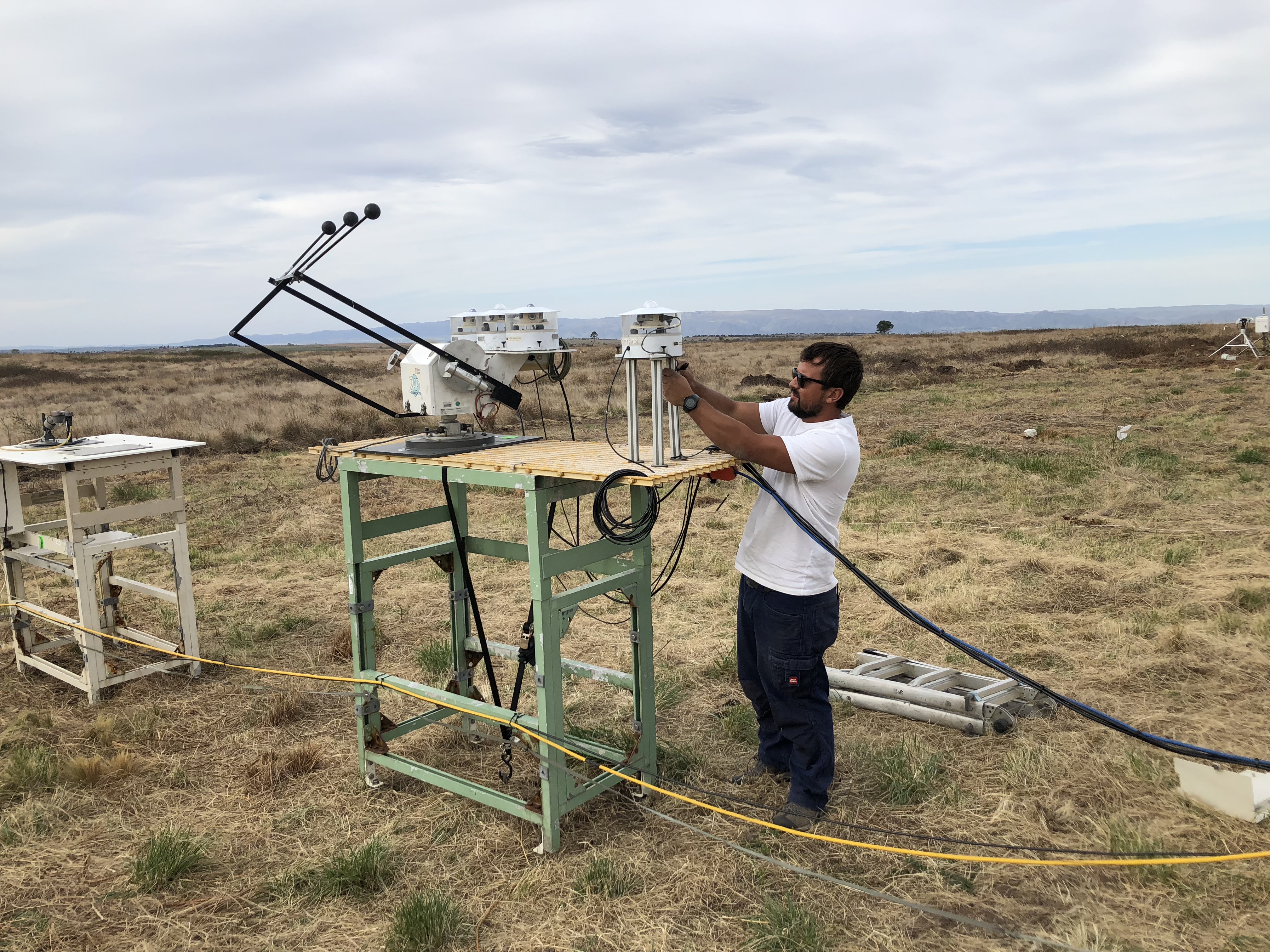 Technician works on ARM sky radiometers on stand for downwelling radiation in Argentina