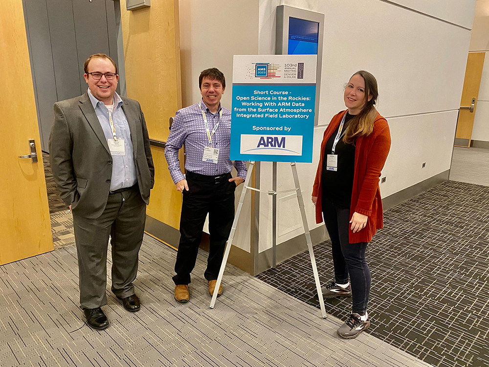 Max Grover, Dan Feldman, and Monica Ihli stand with a sign that says "Short Course - Open Science in the Rockies: Working With ARM Data from the Surface Atmosphere Integrated Field Laboratory sponsored by ARM."