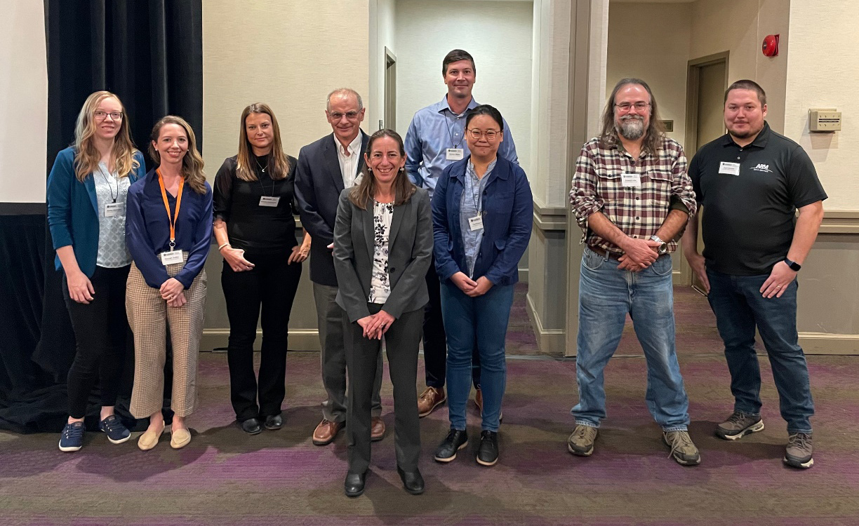 Award winners and DOE/ARM leadership stand together for a photo in a conference room.