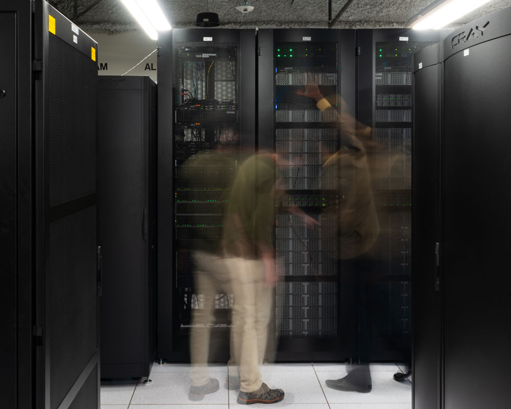 This image shows two people examining a high-performance computing cluster.