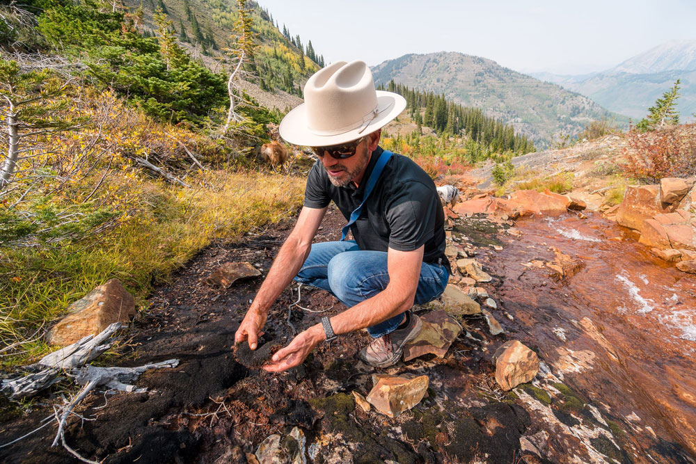 Kenneth H. Williams stoops down to study soil and loose rock.