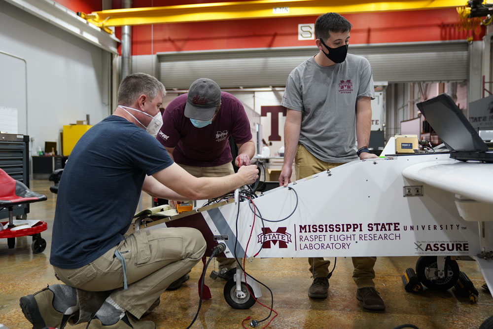 Staff from the ARM Aerial Facility and Raspet Flight Research Laboratory integrate instrumentation into a TigerShark uncrewed aerial system. 