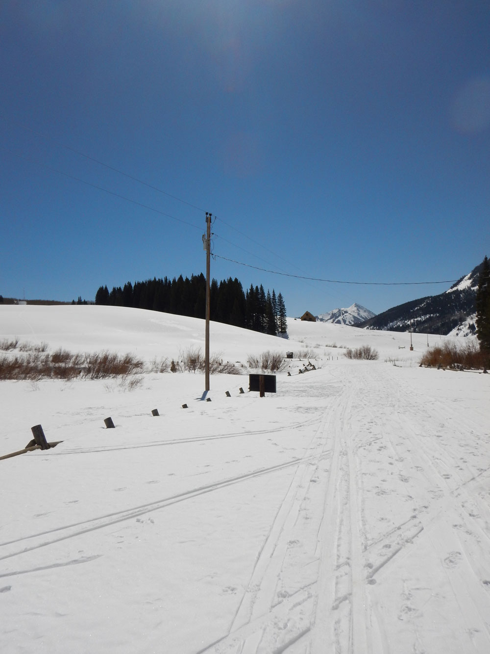 Sun shines above the snow-covered Gothic Road at Gothic Townsite, where the second ARM Mobile Facility will collect measurements during the SAIL campaign
