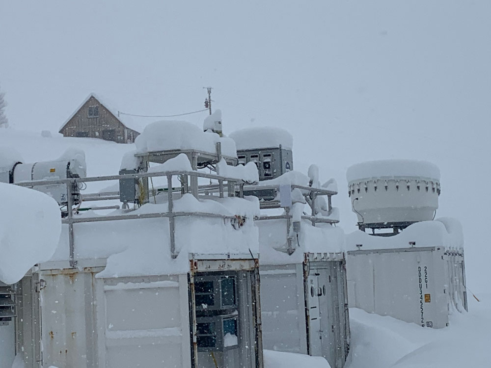Snow covers ARM instruments and containers.