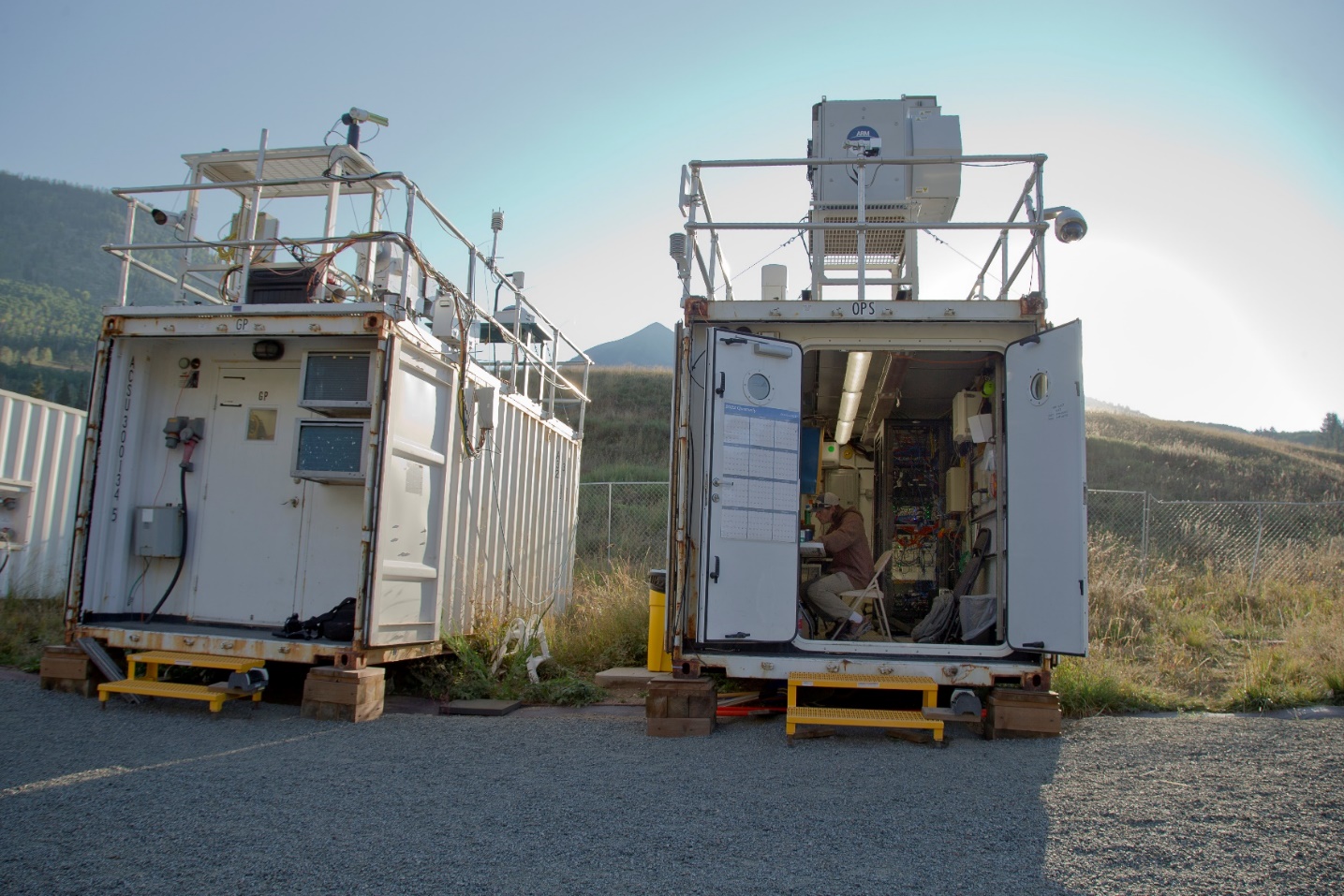 A technician sits at a desk inside an ARM Mobile Facility container.