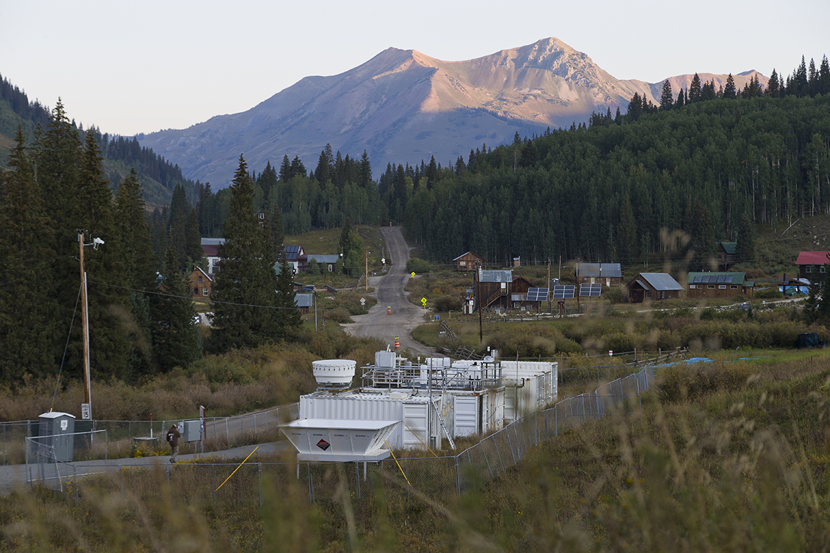 A person walks along the road in front of the ARM Mobile Facility in Gothic, Colorado.