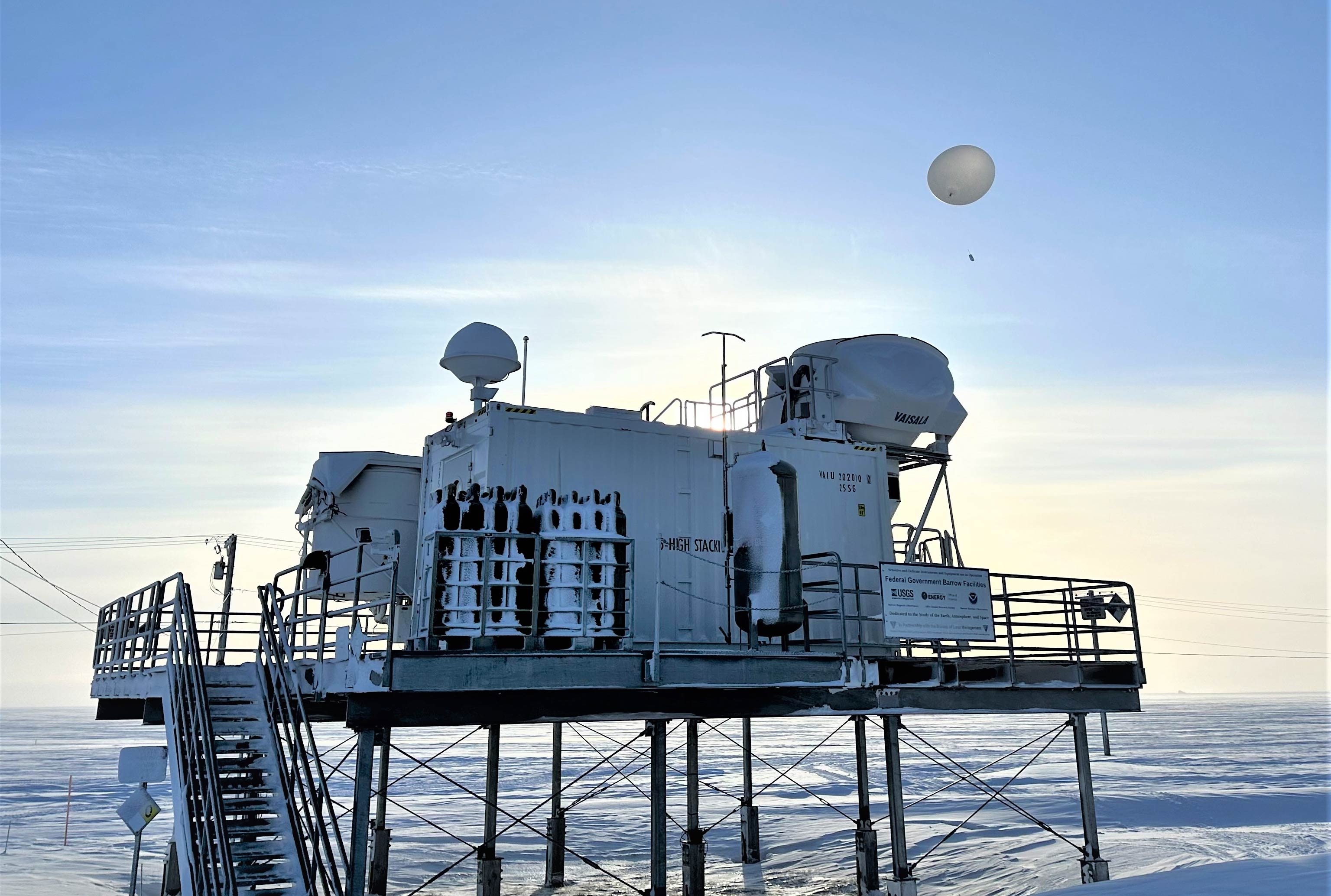 A hydrogen-filled weather balloon floats over ARM instruments.