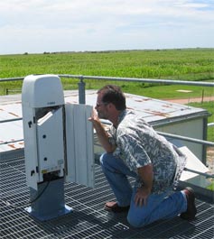 Dan Nelson, SGP facilities manager, inspects the new ceilometer during its evaluation period on the platform of the SGP Guest Instrument Facility between June and July 2008.
