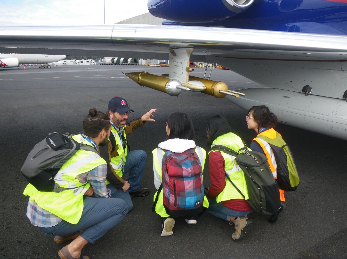 Roger Marchand talking to students in front of an airplane