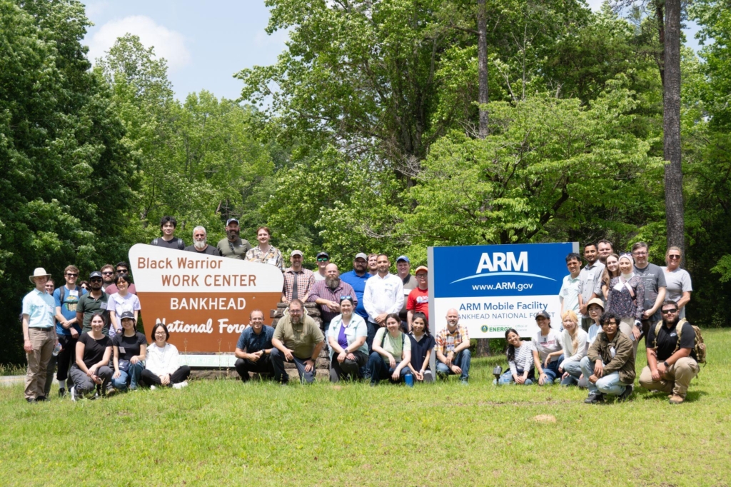 People gather around signs for the Bankhead National Forest ARM Mobile Facility site and neighboring Black Warrior Work Center.