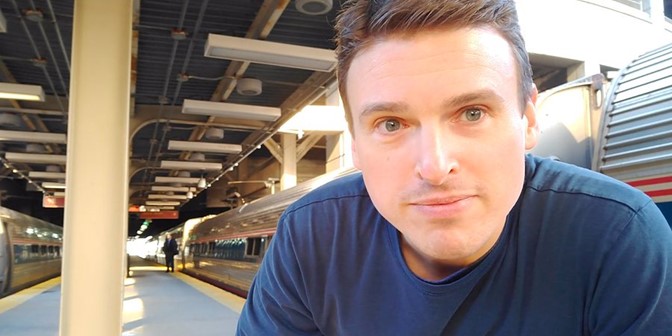 David Romps pauses for a photo at a train station.